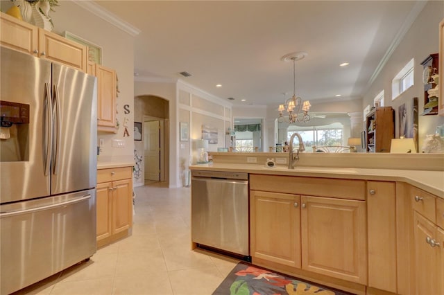 kitchen with light brown cabinetry, stainless steel appliances, decorative light fixtures, ornamental molding, and a chandelier