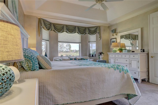 bedroom with crown molding, light colored carpet, a raised ceiling, and ceiling fan