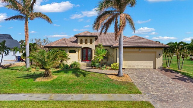 mediterranean / spanish house featuring a front yard and a garage