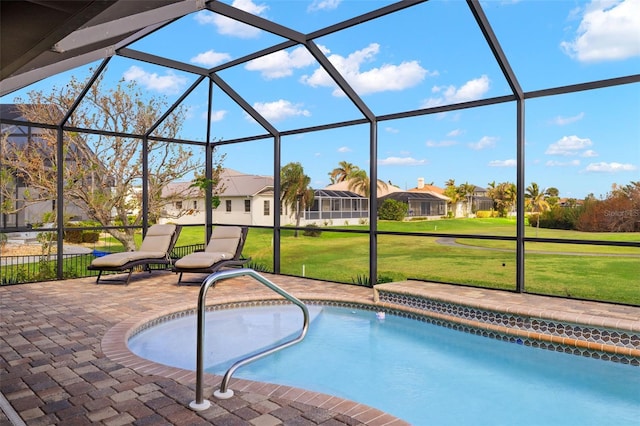 view of swimming pool with a patio, glass enclosure, and a lawn