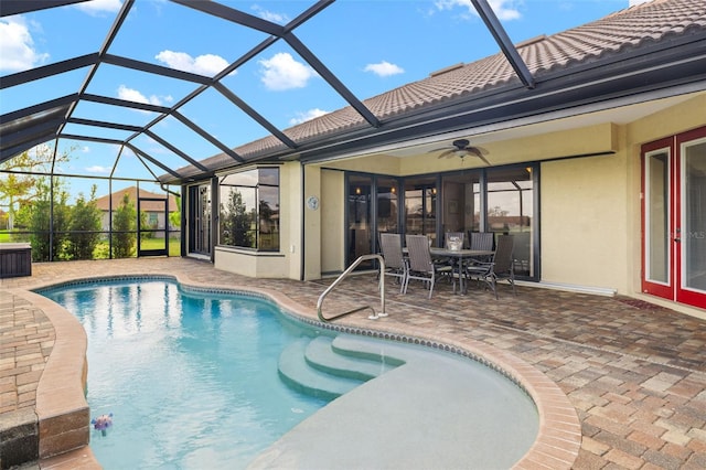 view of swimming pool with a lanai, ceiling fan, and a patio