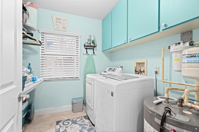 laundry area with cabinets, water heater, washing machine and dryer, and light tile patterned floors