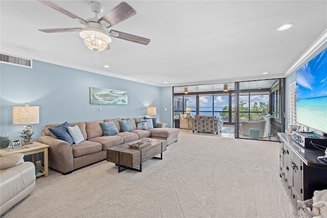 carpeted living room featuring crown molding, expansive windows, and ceiling fan