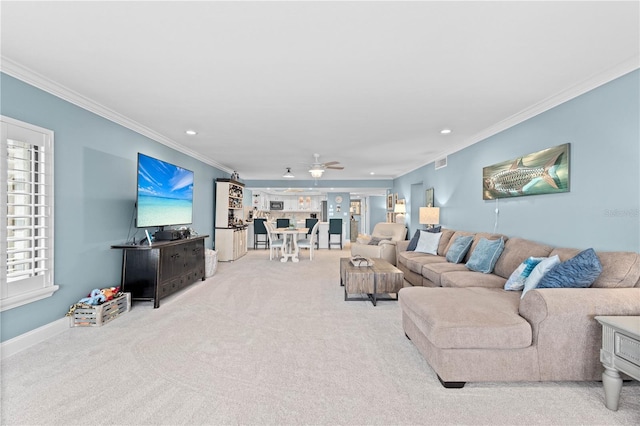 living room featuring ornamental molding, light colored carpet, and ceiling fan