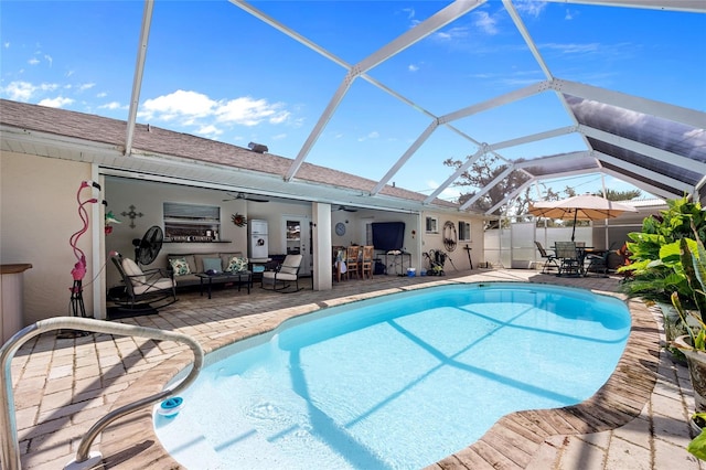 view of pool with a lanai, outdoor lounge area, ceiling fan, and a patio area