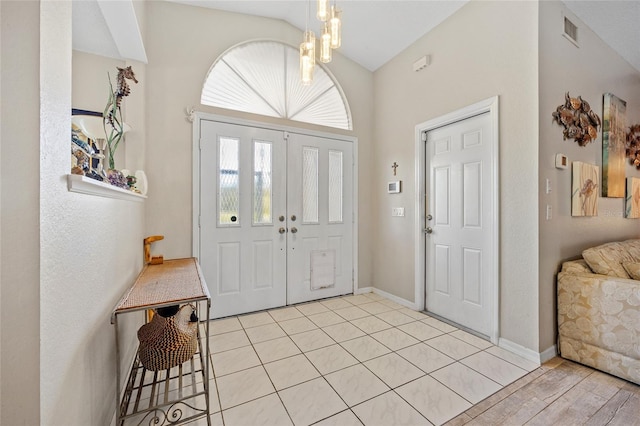 entrance foyer with a chandelier, lofted ceiling, and light hardwood / wood-style flooring