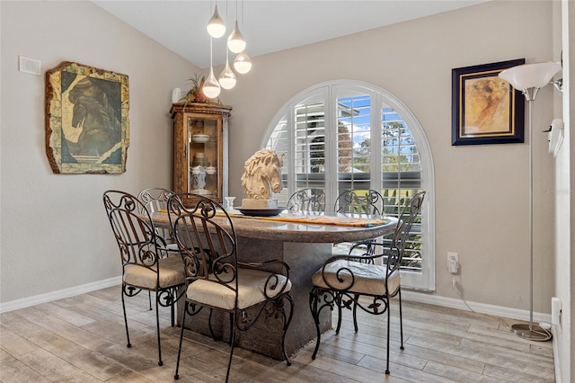 dining area with light hardwood / wood-style flooring and lofted ceiling