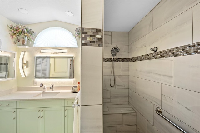 bathroom with vanity, vaulted ceiling, and tiled shower