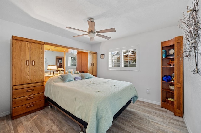 bedroom featuring wood-type flooring, multiple windows, and ceiling fan