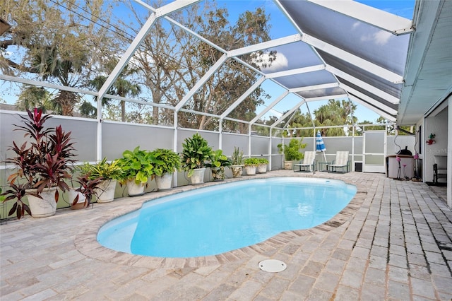 view of swimming pool with a patio and glass enclosure