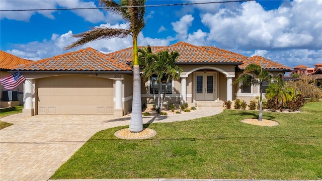 mediterranean / spanish-style home with cooling unit, a front lawn, and a garage