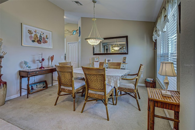 dining room with light carpet and vaulted ceiling