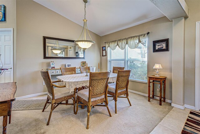 dining space with vaulted ceiling and light colored carpet