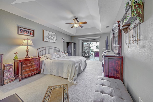 bedroom with access to outside, carpet floors, a raised ceiling, and ceiling fan