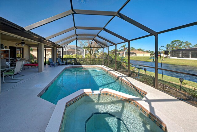 view of swimming pool featuring a patio, ceiling fan, an in ground hot tub, and glass enclosure