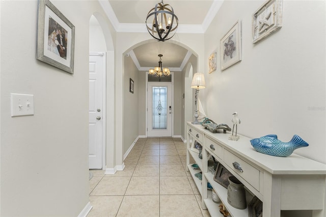 entryway with a notable chandelier, light tile patterned floors, and crown molding