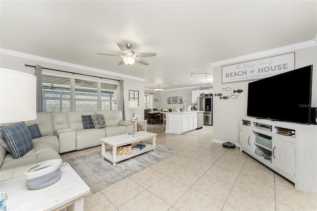 living room featuring ceiling fan, crown molding, sink, and light tile patterned floors