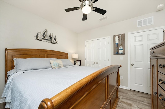 bedroom with light hardwood / wood-style flooring, ceiling fan, and a closet