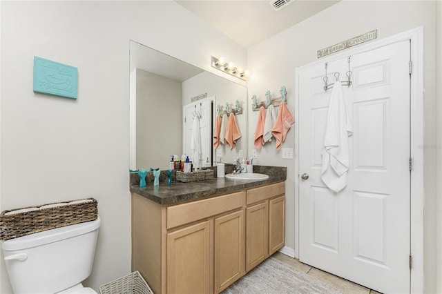 bathroom featuring tile patterned flooring, vanity, and toilet