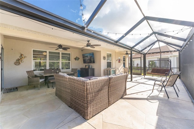 view of patio / terrace featuring ceiling fan, glass enclosure, a jacuzzi, and an outdoor hangout area