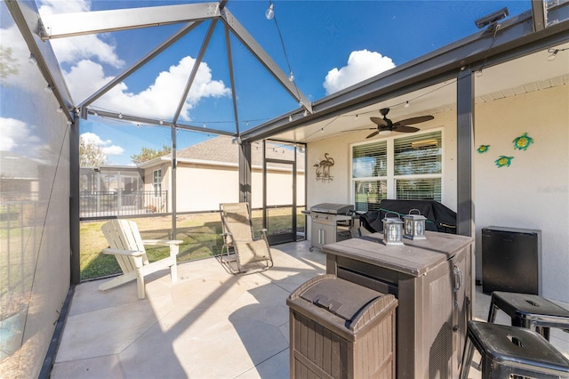 view of patio / terrace featuring ceiling fan and glass enclosure