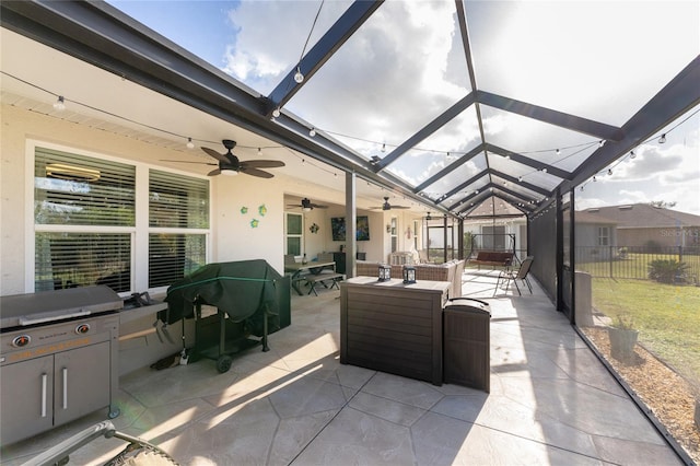 view of patio with glass enclosure, ceiling fan, and an outdoor living space