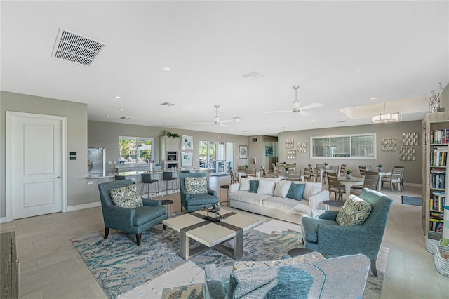 living room with light hardwood / wood-style floors and ceiling fan with notable chandelier