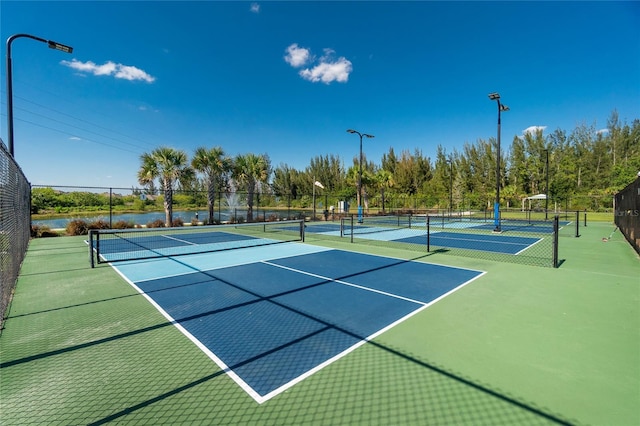 view of tennis court with a water view