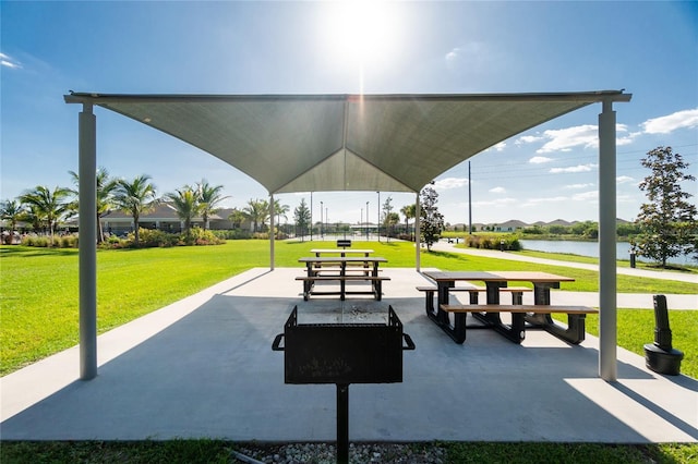 view of home's community featuring a patio area, a yard, and a water view