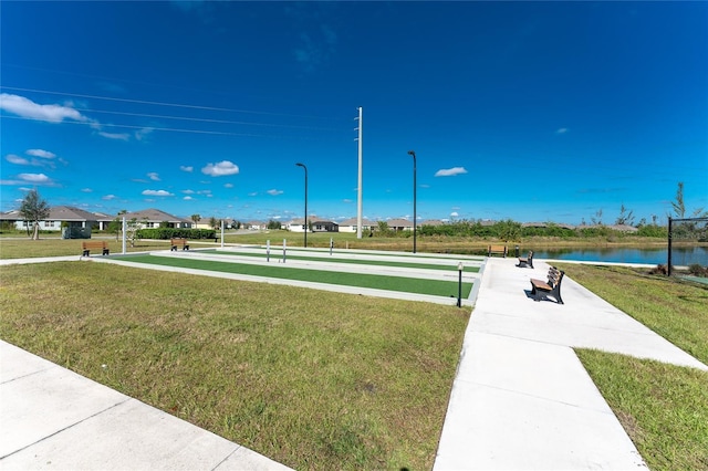 surrounding community with a lawn and a water view