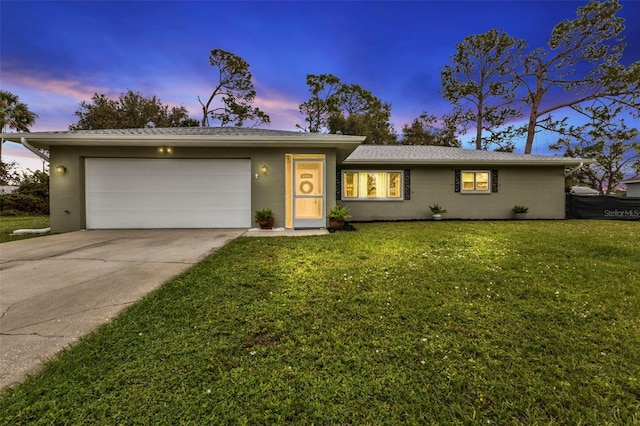 single story home featuring a lawn and a garage