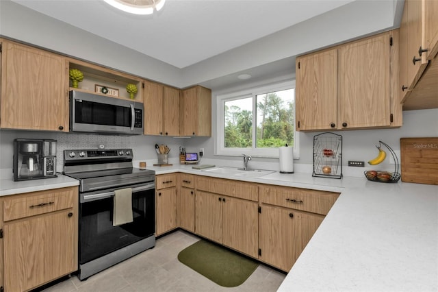 kitchen featuring light brown cabinets, appliances with stainless steel finishes, sink, and light tile patterned flooring