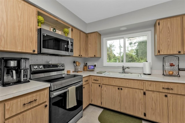 kitchen with light tile patterned flooring, sink, appliances with stainless steel finishes, tasteful backsplash, and light brown cabinetry