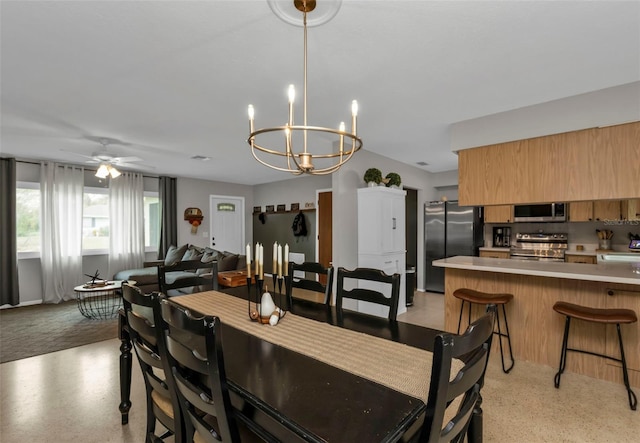 dining room featuring sink and ceiling fan with notable chandelier