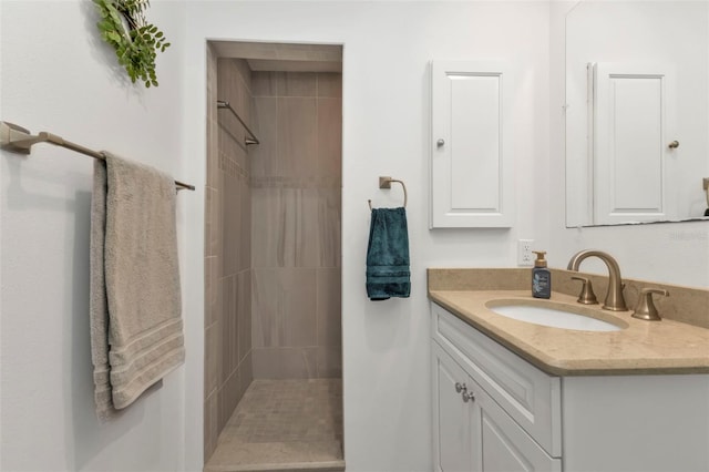 bathroom with vanity and a tile shower