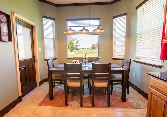 dining room with crown molding, light tile patterned flooring, and plenty of natural light