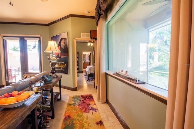 hallway featuring crown molding and light tile patterned floors