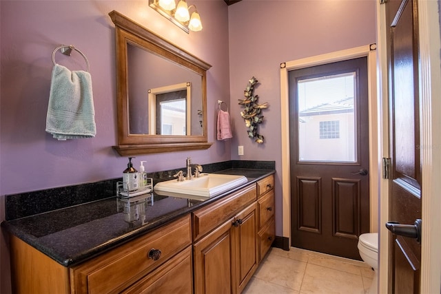 bathroom with toilet, vanity, and tile patterned floors