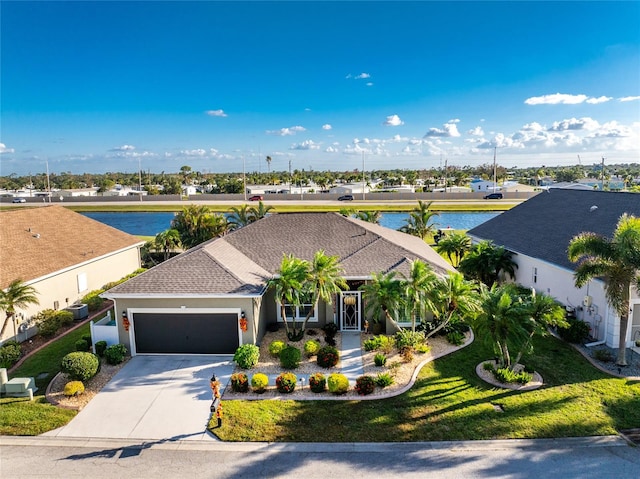 view of front of property featuring a front yard, a garage, and a water view