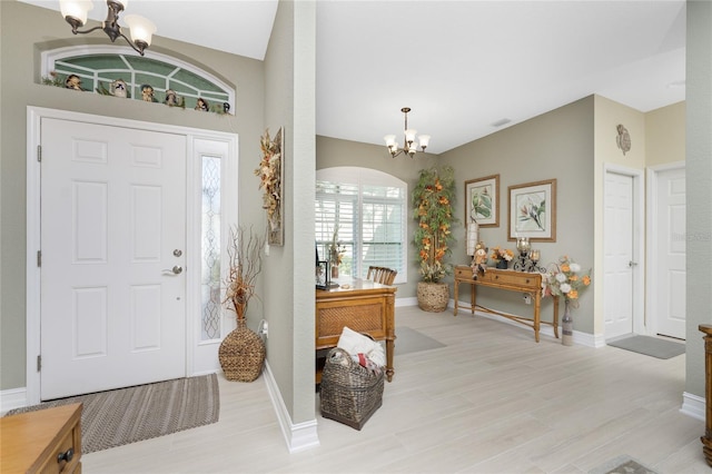 foyer entrance with an inviting chandelier and light wood-type flooring