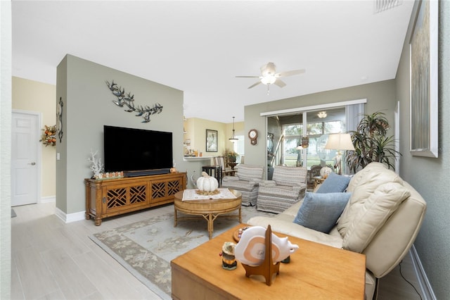 living room with ceiling fan and light wood-type flooring