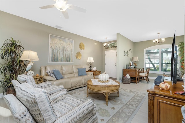 living room with light hardwood / wood-style flooring and ceiling fan with notable chandelier