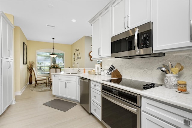 kitchen featuring decorative backsplash, white cabinets, stainless steel appliances, and sink