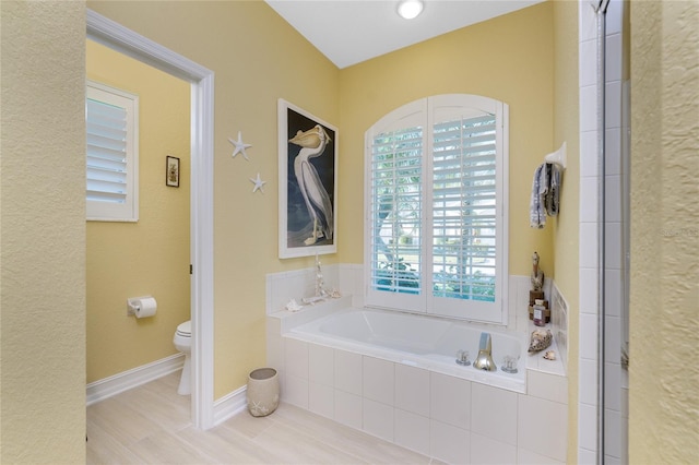 bathroom with shower with separate bathtub, hardwood / wood-style flooring, and toilet