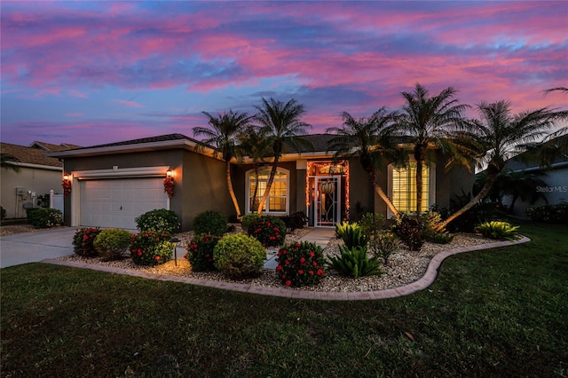 ranch-style home with a yard and a garage