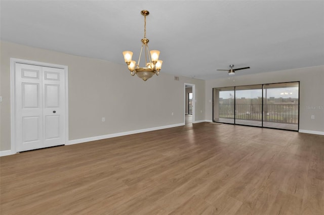 empty room featuring wood-type flooring and ceiling fan with notable chandelier