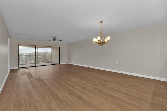 empty room with light hardwood / wood-style flooring and ceiling fan with notable chandelier