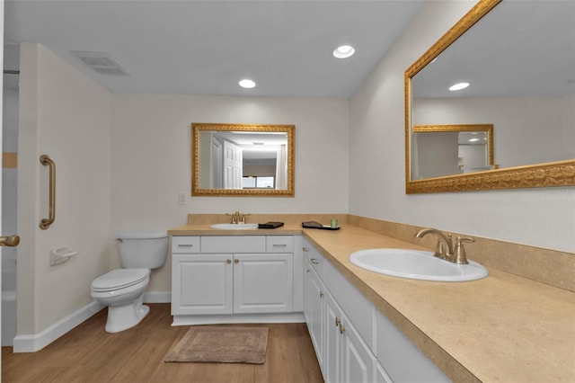 bathroom with vanity, toilet, and hardwood / wood-style floors