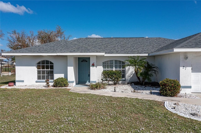 ranch-style house featuring a front yard and a garage