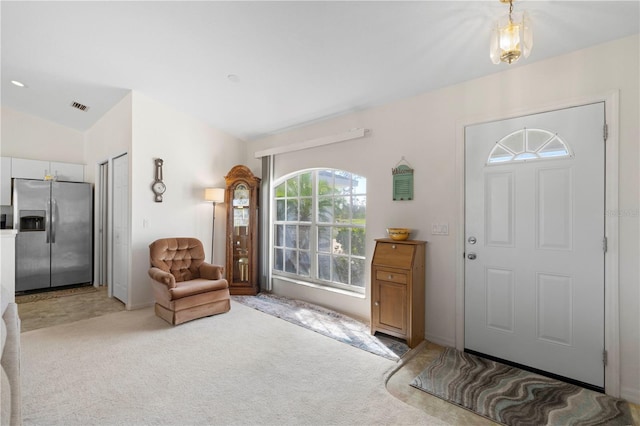 carpeted entryway with vaulted ceiling